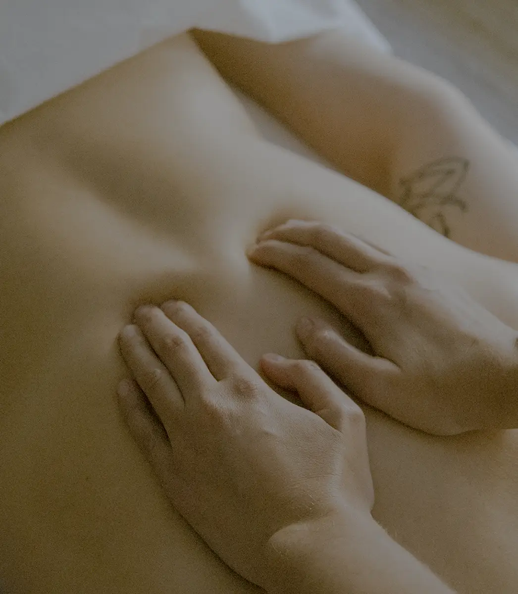Therapeutic massage therapist applying hands-on bodywork to a client’s back