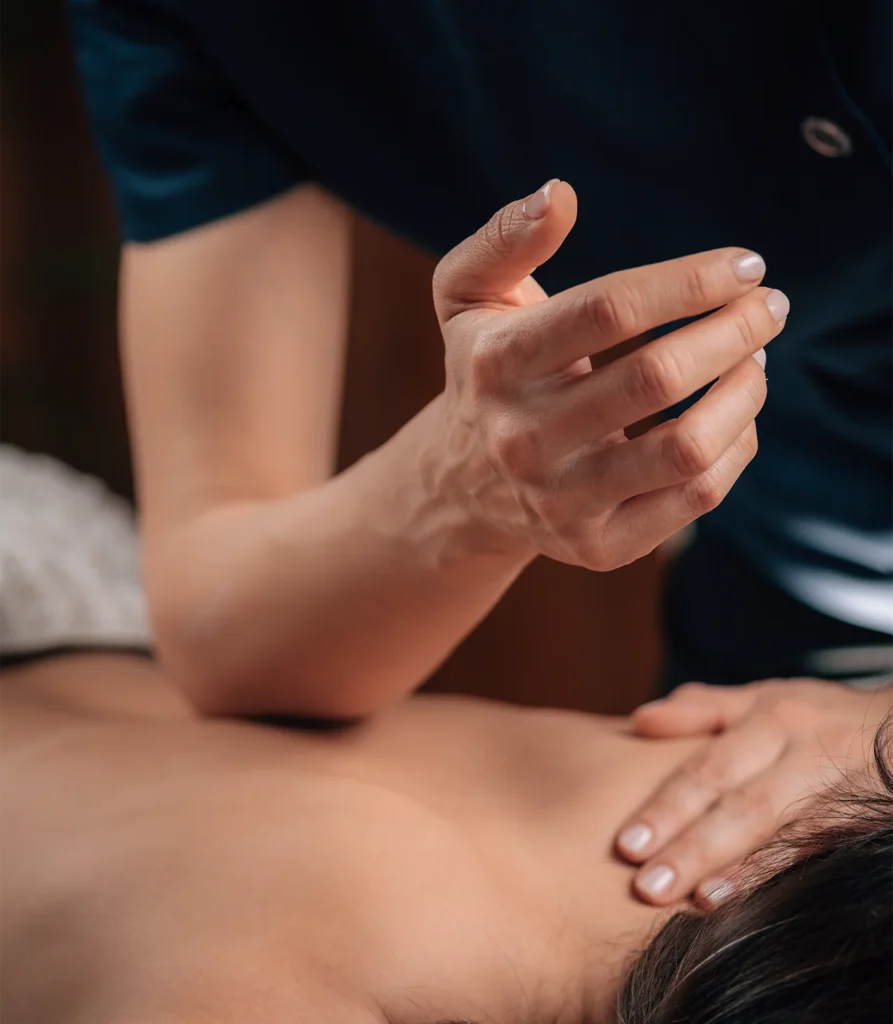 Massage therapist providing focused therapeutic bodywork to a client at Premaveda